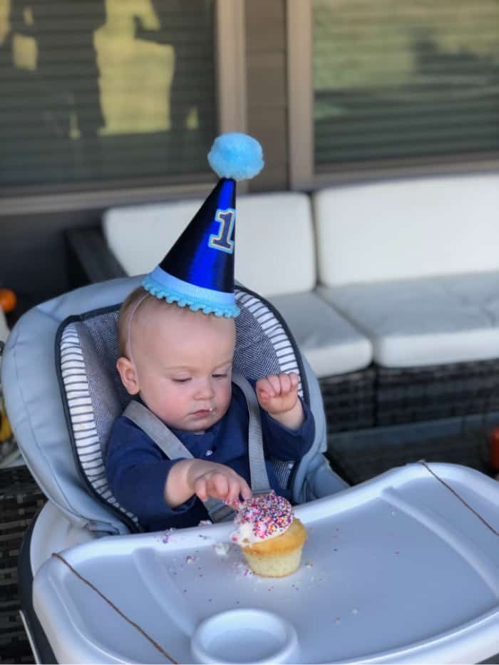 Jacob in his high chair about to eat a sprinkle cupcake