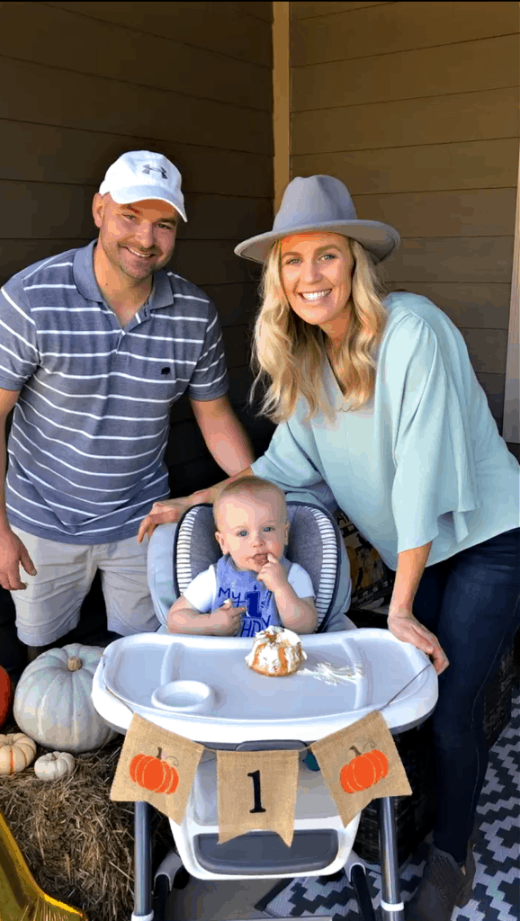 Joey and Lindsey standing next to Jacob's high chair as he eats cake. 