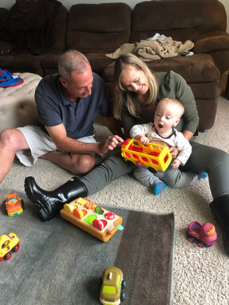 A very happy Jacob playing with his gifts on the floor with Grammy & Grampy.