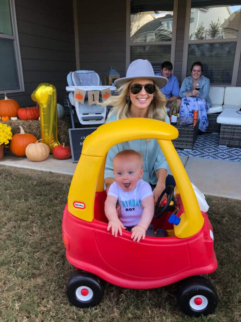 Lindsey with Jacob as he smiles big in his car.