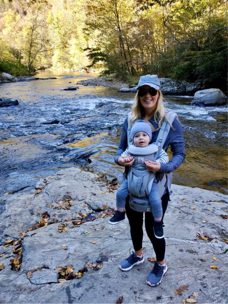 Lindsey with Jacob in the ergo carrier on the rocks on the river