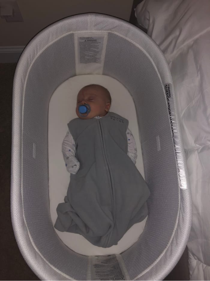 Jacob sleeping on his back in the bassinet in a sleep sack