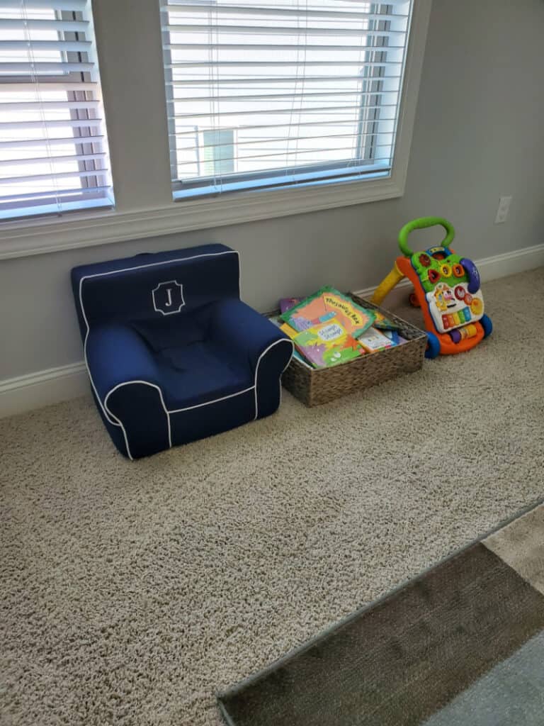 Tiny chair next to a basket of books.