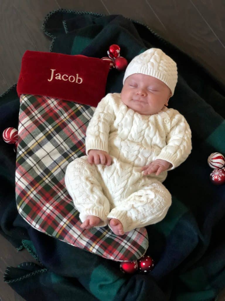 Newborn Jacob laying next to his stocking. 