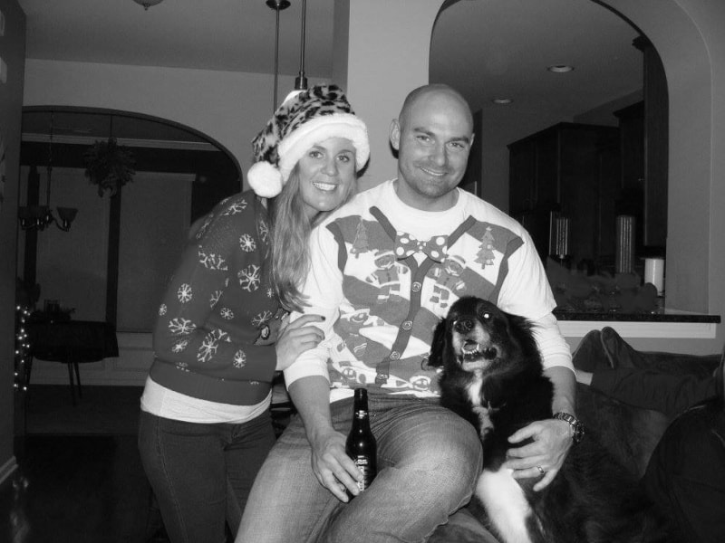 Joey and Lindsey in ugly Christmas sweaters and Bentley smiling with them