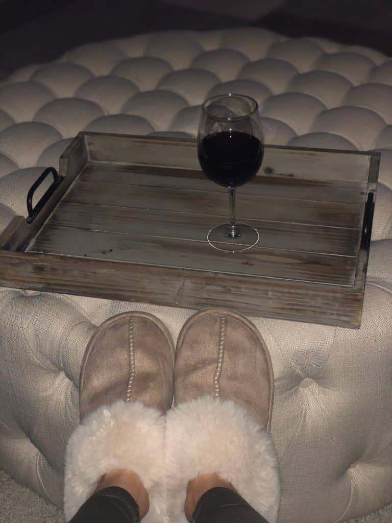 Lindsey's slippers on the ottoman and a glass of red wine